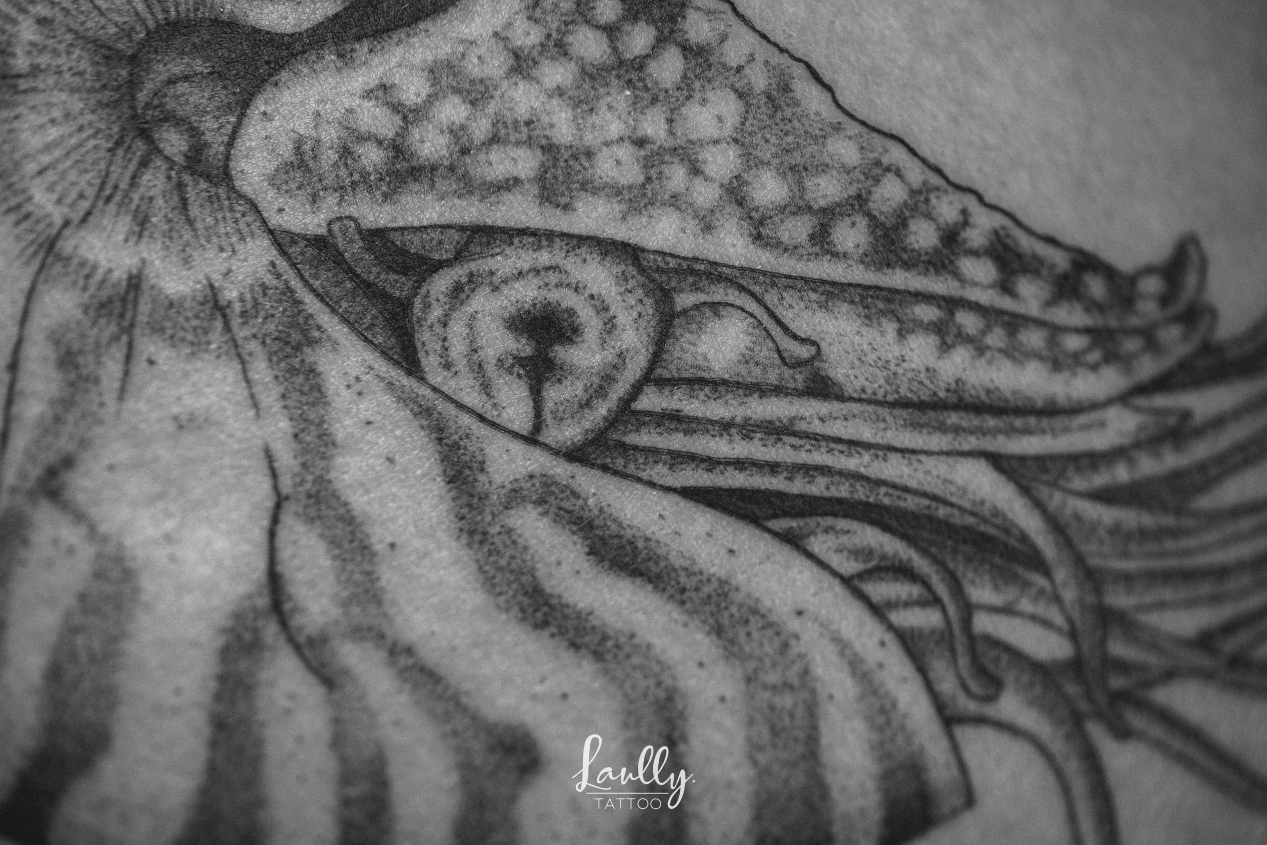 Un Nautilus tatouée sur une cuisse à la main de bois